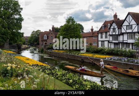 Touristen, die auf dem Fluss in canterbury, großbritannien, herumschlagen, umgeben von Blumen Stockfoto