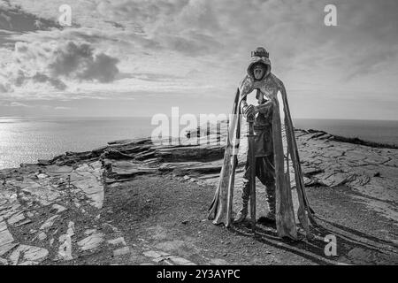 Einfarbiges Bild der Bronze-Gallos-Statue, die auf den Klippen des Schlosses Tintagel steht. Stockfoto