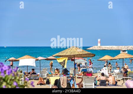 Kusadasi, Türkei - 1. September 2024: Lebhafter Strand in Kusadasi, Türkei, bei Belediye Plaji mit vielen Urlaubern, die Sonne und Meer im Sommer genießen *** Belebter Strand in Kusadasi, Türkei, am Belediye Plaji mit vielen Urlaubern, die Sonne und Meer im Sommer genießen Stockfoto