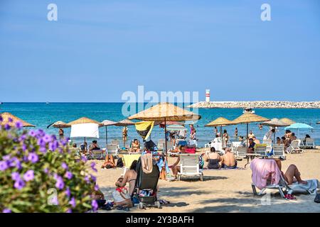 Kusadasi, Türkei - 1. September 2024: Lebhafter Strand in Kusadasi, Türkei, bei Belediye Plaji mit vielen Urlaubern, die Sonne und Meer im Sommer genießen *** Belebter Strand in Kusadasi, Türkei, am Belediye Plaji mit vielen Urlaubern, die Sonne und Meer im Sommer genießen Stockfoto