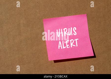 Virenwarnmeldung auf rosafarbenem Papier mit Papphintergrund geschrieben. Konzeptionelles Virus-Warnsymbol. Kopierbereich. Stockfoto