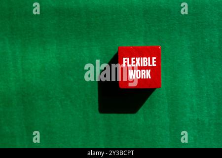 Flexible Arbeitsbotschaft auf rotem Holzwürfel mit grünem Hintergrund. Konzeptionelles flexibles Arbeitssymbol. Kopierbereich. Stockfoto