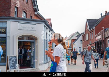 Frau macht Seifenblasen in der Fußgängerzone Stockfoto