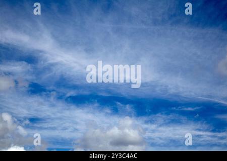Ein wunderschöner, klarer blauer Himmel mit weichen weißen Wolken, die an einem sonnigen Tag eine ruhige und friedliche Atmosphäre schaffen. Stockfoto