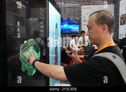 (240913) -- PEKING, 13. September 2024 (Xinhua) -- Ein Besucher interagiert mit einem digitalen holografischen Bildschirm während der China International Fair for Trade in Services (CIFTIS) 2024 im Shougang Park in Peking, Hauptstadt von China, 13. September 2024. Das CIFTIS 2024 findet vom 12. Bis 16. September im China National Convention Center und im Shougang Park in Peking unter dem Motto „Global Services, Shared Prosperity“ statt. (Xinhua/Chen Yehua) Stockfoto