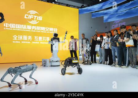 (240913) -- PEKING, 13. September 2024 (Xinhua) -- Besucher sehen eine Vorstellung von Robotergeräten während der China International Fair for Trade in Services (CIFTIS) 2024 im China National Convention Center in Peking, Hauptstadt von China, 13. September 2024. Das CIFTIS 2024 findet vom 12. Bis 16. September im China National Convention Center und im Shougang Park in Peking unter dem Motto „Global Services, Shared Prosperity“ statt. (Xinhua/Cao Mengyao) Stockfoto