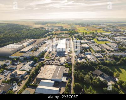 Zahlreiche Gebäude und Straßen in einem Industriegebiet, umgeben von einer bewaldeten Landschaft unter sonnigem Himmel, Wolfsberg Industriegebiet, Nagold, Black Fores Stockfoto