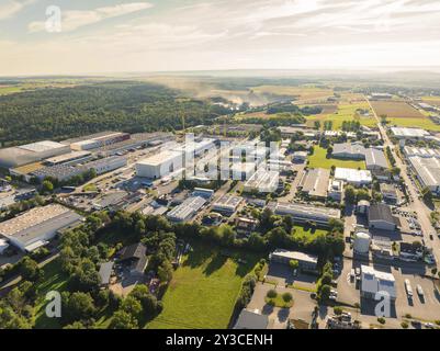 Industriegebiet mit zahlreichen Gebäuden und Straßen, umgeben von großen offenen Feldern unter sonnigem Himmel, Industriegebiet Wolfsberg, Nagold, Schwarzwald Stockfoto