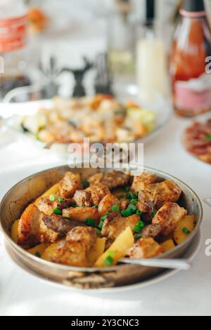 Gegrilltes Schweinefleisch mit Zwiebeln und Champignons, serviert mit gebackenen Kartoffeln Stockfoto