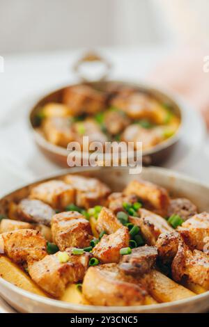 Gegrilltes Schweinefleisch mit Zwiebeln und Champignons, serviert mit gebackenen Kartoffeln. Stockfoto