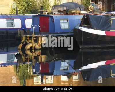 Alte schmale Boote und Lastkähne, die in Hausboote umgebaut wurden, die im Yachthafen im brighouse Basin in West yorkshire vertäut sind Stockfoto