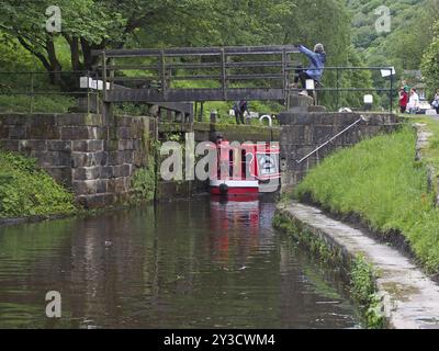 Hebden Bridge, West yorkshire, vereinigtes Königreich, 16. juni 2019: Eine Gruppe von Menschen, die ein Schmalboot durch ein schleusentor am rochdale-Kanal in hebden nehmen Stockfoto