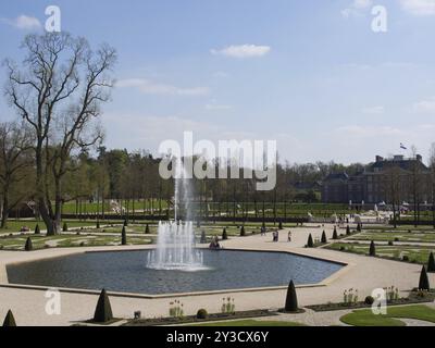 Schlosspark mit einem zentralen Brunnen, geometrischen Wegen und gepflegter Landschaft, Apeldoorn, Niederlande Stockfoto