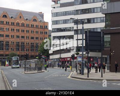 Leeds, West yorkshire, vereinigtes Königreich, 18. juni 2019: Busse und Fußgänger überqueren die Straße in der Krankenstation leeds mit umliegenden Bürogebäuden Stockfoto