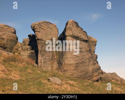 Große, zerklüftete Gritsteinausläufer an den Bridestonen einer großen Felsformation in West yorkshire in der Nähe von todmordendem blauem Himmel und umliegender Landschaft Stockfoto