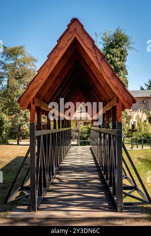 Perspektivischer Blick durch Fußgängerbrücke mit Holzgiebeldach Stockfoto