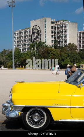 Amerikanischer Cadillac vor einem Regierungsgebäude, Plaza de la Revolucion, Havanna, Kuba, 2024. Ein wunderschön restaurierter alter Cadillac vor dem Stahlgemälde von Che Guevara auf der Seite des Innenministeriums. Stockfoto