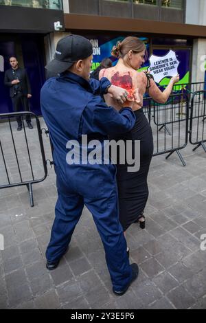 London, Großbritannien. September 2024. Ein PETA-Mitglied gibt vor, während der Demonstration die Haut von der Rückseite eines anderen Aktivisten zu ziehen. Mitglieder von PETA (People for the Ethical Treatment of Animals) hielten eine Demonstration gegen die Verwendung von Leder in Kleidung vor einem der Veranstaltungsorte der London Fashion Week ab. Quelle: SOPA Images Limited/Alamy Live News Stockfoto