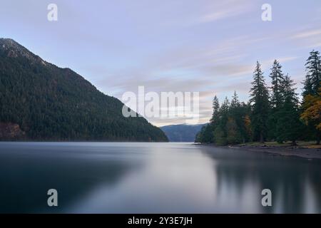 Friedlicher Herbstmorgen vor Sonnenaufgang am Lake Crescent im Olympic National Park, Washington, USA, mit pastellfarbenem Himmel und schimmernden Wolken, die sich im Wasser spiegeln Stockfoto