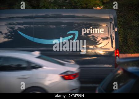 LOS ANGELES, CA - 13. März 2024: Amazon Prime Delivery Truck liefert Pakete auf einer belebten Wohnstraße in Hollywood bei Sonnenuntergang. Stockfoto