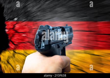 Bayern, Deutschland - 13. September 2024: Person zeigt mit der Waffe auf die deutsche Flagge. Konzeptwaffenrechte, politische Debatte über Waffenverbotszonen und Waffengesetze in Deutschland oder der Bundesrepublik Deutschland. PHOTOMONTAGE *** Person richtet Waffe auf Deutschland-Fahne. Konzept Waffenrechte, politische Debatte Waffenverbotszonen und Waffengesetze in Deutschland bzw. Der deutschen Bundesrepublik. FOTOMONTAGE Stockfoto