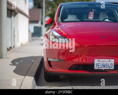 LOS ANGELES, KALIFORNIEN - 4. März 2024: Elektroauto Tesla Model Y parkt auf dem Bürgersteig in West Hollywood. Selektiver Fokus auf Scheinwerfer Stockfoto
