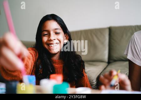 Kunst, schwarzes Kindergemälde auf Leinwand mit Pinsel und Farben zu Hause. Handwerk, kreative Aktivität Stockfoto