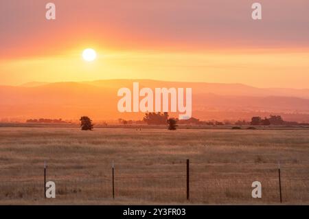 Rauch von waldbränden Farben Sonnenaufgang über den Bergen der Sierra Nevada in der Nähe von Palermo, Kalifornien Stockfoto