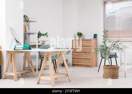 Innenraum des Ingenieurbüros mit Arbeitsplatz, Anlagen und Windkraftanlagenmodellen Stockfoto