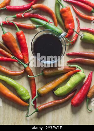 Vintage-Kaffee und farbenfrohe Chili-Paprika auf Holztisch Stockfoto