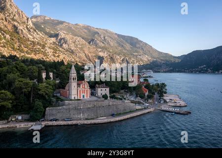 Blick aus der Vogelperspektive auf die alte Kirche in der Bucht von Kotor mit Hafen im Hintergrund Stockfoto