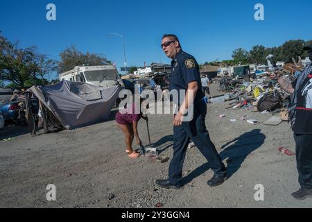 Sacramento, ca. 9. August 2024. Feuerwehrmarschall Jason Lee von der Sacramento Feuerwehr überblickt das Obdachlose Lager Camp Resolution, während ein Bewohner das Lager am Freitag, den 9. August 2024, weiter säubert. „Ich freue mich sehr, dass hier viel Arbeit geleistet wurde“, sagte er. Die meisten Bewohner blieben die ganze Nacht wach und schufen einen Müllhaufen, den die Stadt abholen konnte. (Kreditbild: © Renée C. Byer/ZUMA Press Wire) NUR REDAKTIONELLE VERWENDUNG! Nicht für kommerzielle ZWECKE! Stockfoto