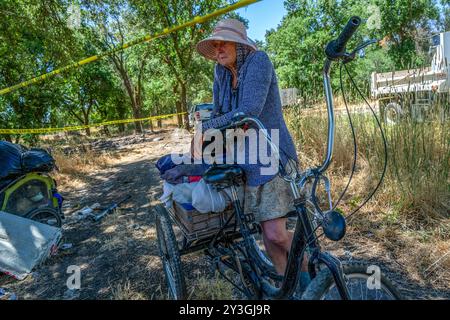 Sacramento, ca. 17. Juni 2024. Carol Dutcher, 60 Jahre alt, sitzt zwischen Polizeiaufnahmen, nachdem sie einige ihrer Sachen während einer Rückführung in einem Obdachlosen-Lager, in dem sie die letzten vier Jahre in Rio Linda gelebt hatte, am Montag, den 17. Juni 2024 bewegt hatte. "Es ist ihnen egal, dass sie mein Haus zerstört haben und ich habe heute Abend keinen Platz zum Schlafen," sagte sie unter Tränen. "Könntest du dein ganzes Haus in zwei Tagen, vier Tagen umziehen", sagte sie.¦Ich glaube nicht, dass es jemand könnte. (Kreditbild: © Renée C. Byer/ZUMA Press Wire) NUR REDAKTIONELLE VERWENDUNG! Nicht für kommerzielle ZWECKE! Stockfoto