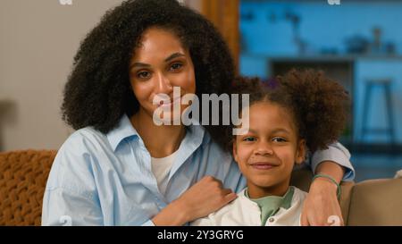 Afroamerikanische Mutter und Tochter auf dem Sofa Arzt Termin Logopädin Psychologe Kinderarzt glückliche Familie Haus Liebe Frau Mädchen Beziehungen Stockfoto