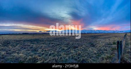 Pulsierender Sonnenuntergang über der schneebedeckten Bergkette in der Nähe von Twizel Stockfoto