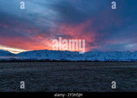 Pulsierender Sonnenuntergang über der schneebedeckten Bergkette in der Nähe von Twizel Stockfoto