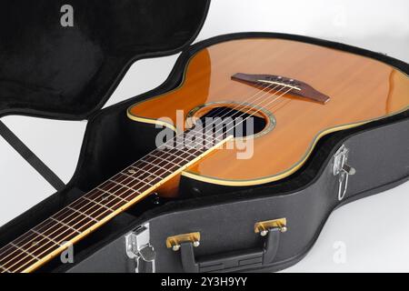 Musikinstrument - Fragment Vintage elektrische Akustikgitarre im Hartschalenkoffer auf weißem Hintergrund. Stockfoto