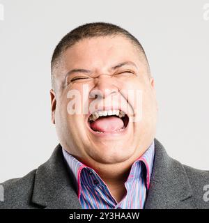 Geschäftsmann, glücklich und lachend im Studio für lustigen Witz, Komödie und Selbstvertrauen mit positiver Stimmung. Männlicher Mensch, aufgeregt und witzig auf weiß Stockfoto