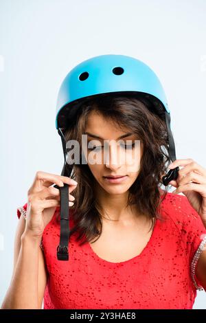 Fahrradhelm, Sicherheit oder Frau im Studio für Schutz, Mode oder Ästhetik. Weibliche Person, blauer Hut oder Vorbereitung auf weißem Hintergrund für Reisen Stockfoto