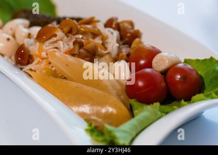 Gourmet-Platte mit eingelegtem Gemüse und Kirschtomaten auf elegantem Serviergericht. Stockfoto
