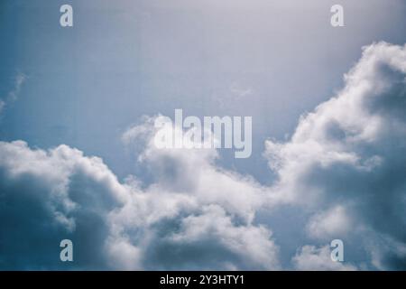 Halten Sie die Essenz der Ruhe mit diesem Stockbild fest, das weiche, flauschige Wolken über einem beruhigenden blauen Himmel verstreut zeigt. Der sanfte Kontrast zwischen Stockfoto