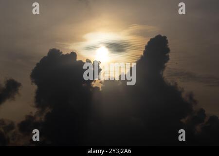 Sonnenstrahl bricht durch die dunklen Wolken am Morgenhimmel. Stockfoto