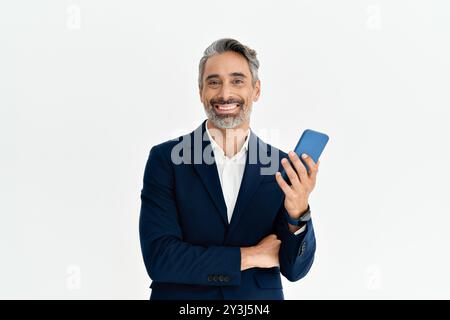 Glücklicher Geschäftsmann im mittleren Erwachsenenalter, der Anzug mit Telefon auf weiß trägt. Stockfoto