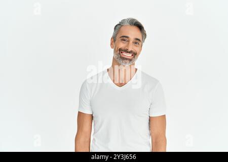 Lächelnder reifer Mann, der ein T-Shirt auf weißem Hintergrund trägt. Hochformat. Stockfoto