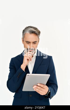 Beschäftigter Geschäftsmann mittleren Alters, der mit einem digitalen Tablet über Fragen nachdenkt. Stockfoto