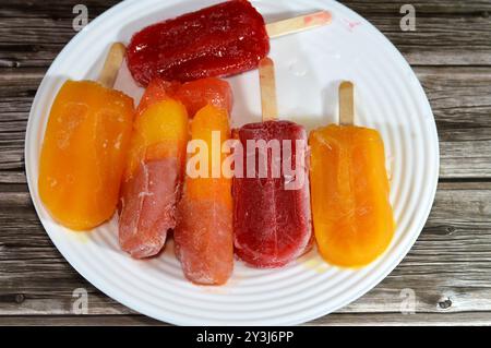 Eisbars aus echten Früchten von Mango und gemischten Beeren, eine Eisbar ist ein gefrorenes Dessert mit Eis auf einem Stock, Sommer und Urlaub Stockfoto