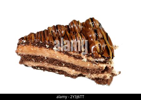 Ein dreieckiges, schwammiges Kuchenstück aus Schokolade, gefüllt mit Schichten Schokoladenpaste Creme und Kugelstücken, mit Kuchenschichten, serviert auf einer Platte Stockfoto