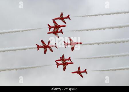 Neun Hawk Jet Trainer des British Royal Air Force Red Arrows Kunstflugteams führen während ihrer Ausstellung ihr atemberaubendes 5/4 Cross Manöver durch Stockfoto