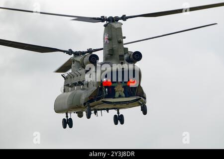 RAF Helicopter Loadmaster trägt große orangene Handschuhe und winkt aus seinem Boeing Chinook Dual Rotor Heavy Lift Helicopter beim RIAT Stockfoto