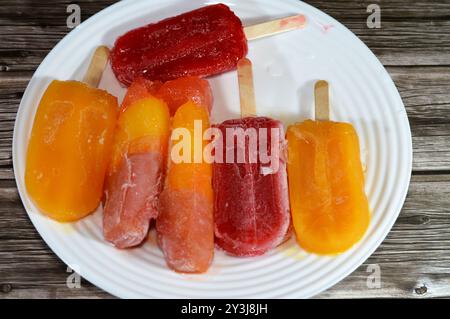 Eisbars aus echten Früchten von Mango und gemischten Beeren, eine Eisbar ist ein gefrorenes Dessert mit Eis auf einem Stock, Sommer und Urlaub Stockfoto